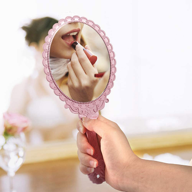 Ovalt dekorativt lyserødt håndholdt spejl