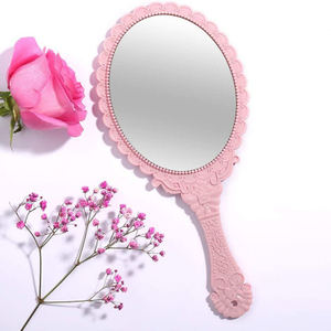 Ovalt dekorativt lyserødt håndholdt spejl