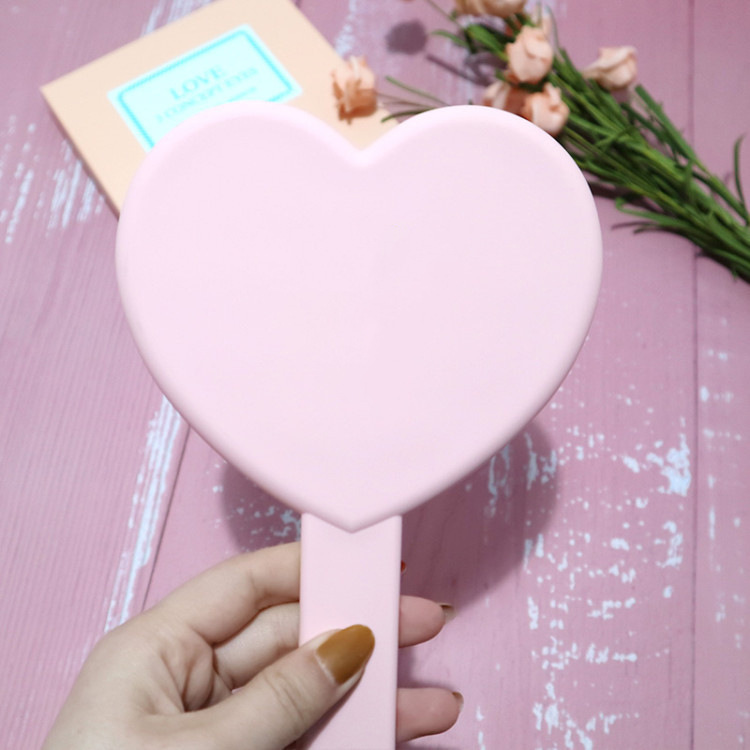 Hjerteformet lille lyserødt håndholdt spejl